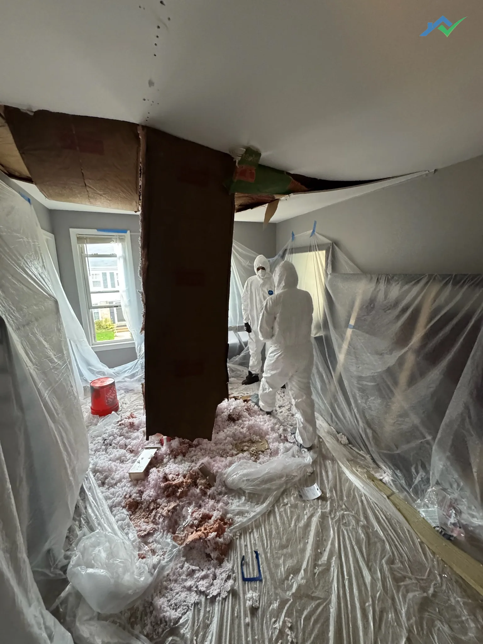 The old Burke ceiling pulled down to the joists during demolition, insulation and debris contained on plastic sheeting.