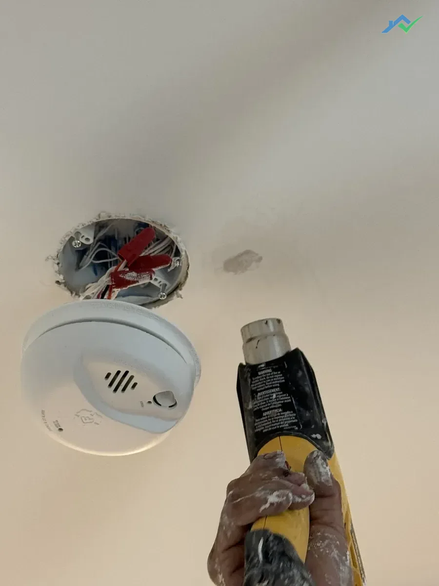 HouseWorks tech Eduardo applying joint compound to ceiling patch in Ashburn VA home