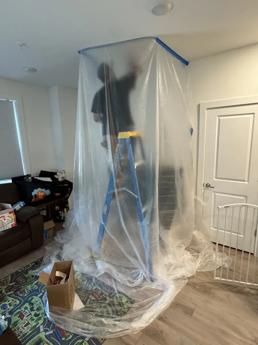 Sanding and smoothing ceiling drywall repair before painting