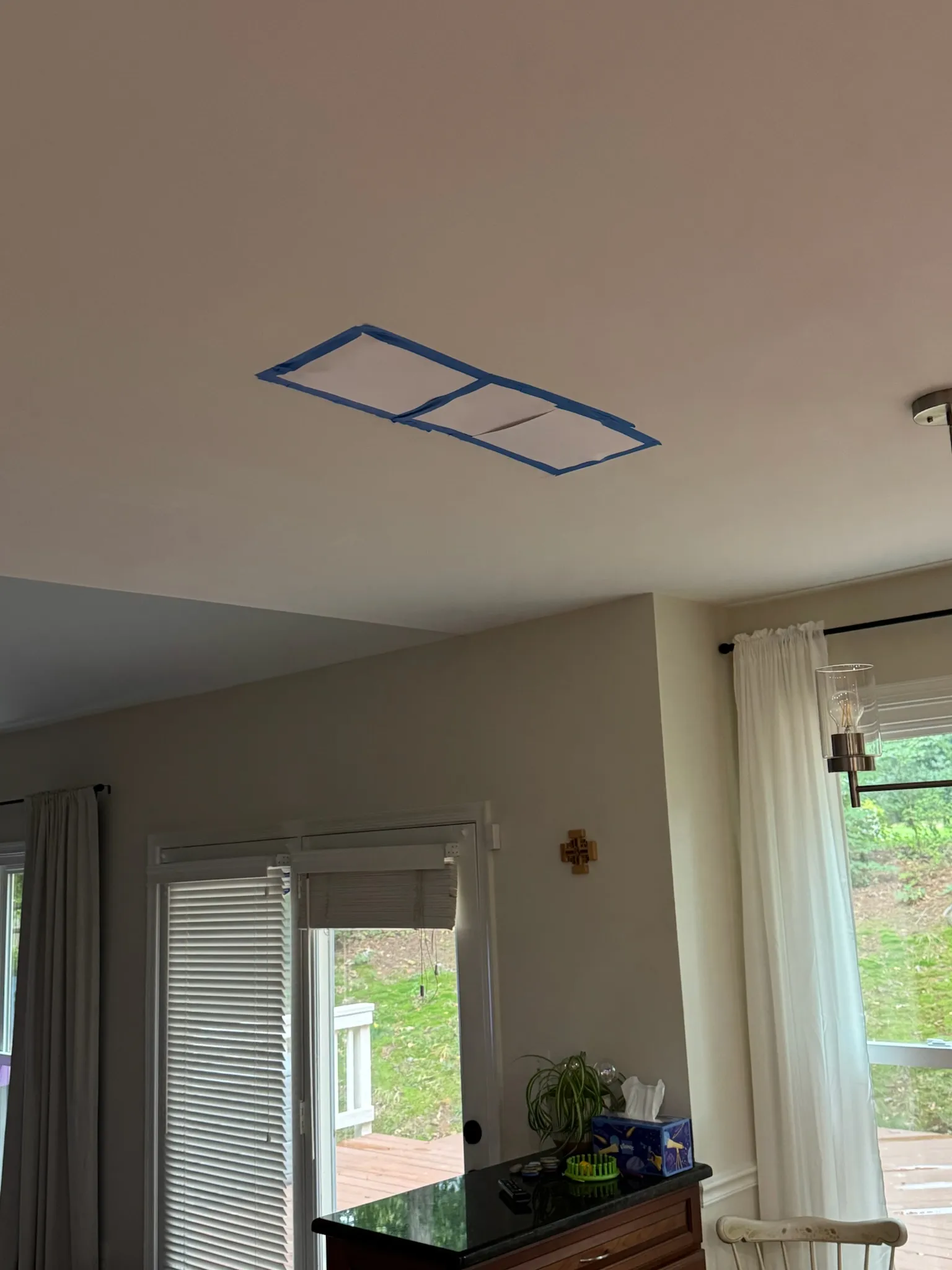 A blue-taped stain outline on the Fairfax Station kitchen ceiling marking the damaged drywall before repair begins.