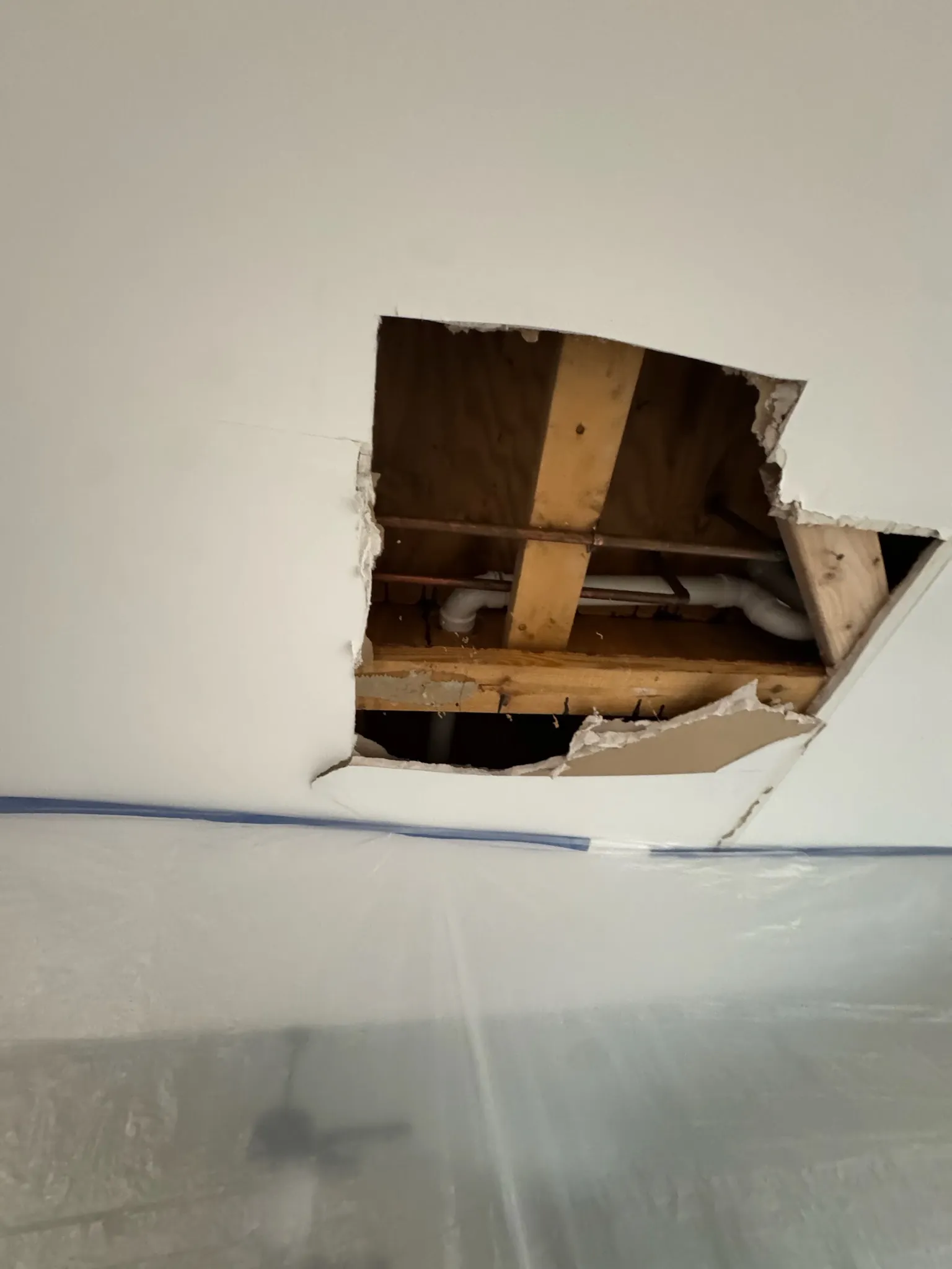 Kitchen ceiling opened up, exposing water stained subfloor.