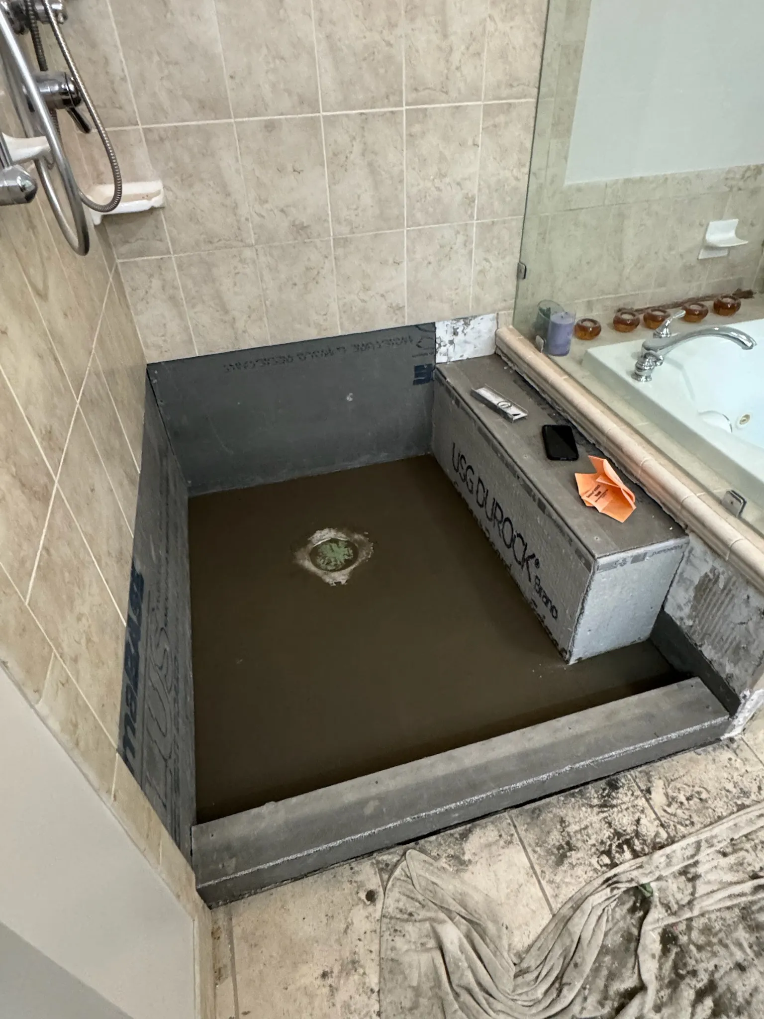 Shower pan properly packed and sloped to the drain, with the waterproofing membrane ready to be installed.