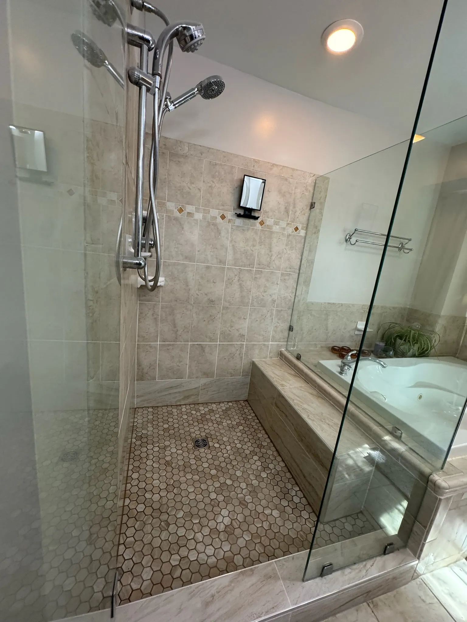 The rebuilt shower finished — new tile with the glass enclosure reinstalled.