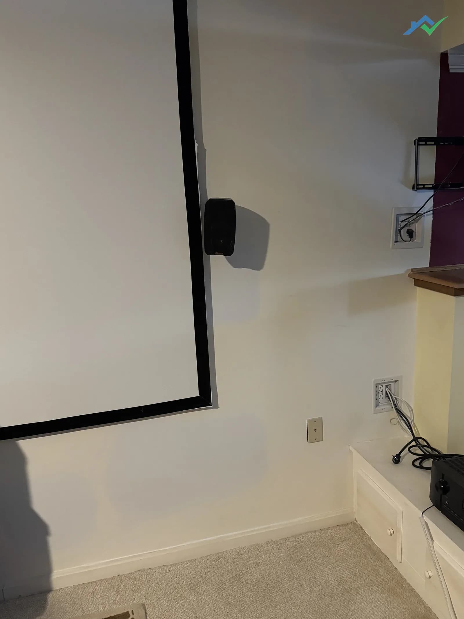 Same basement home-theater wall in the Purcellville, VA home where several old patches used to sit — everything is now sanded flush and primed, ready for the homeowner's topcoat.