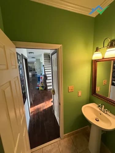 Finished guest bathroom wall with fresh paint and seamless drywall repair blended into the surface.