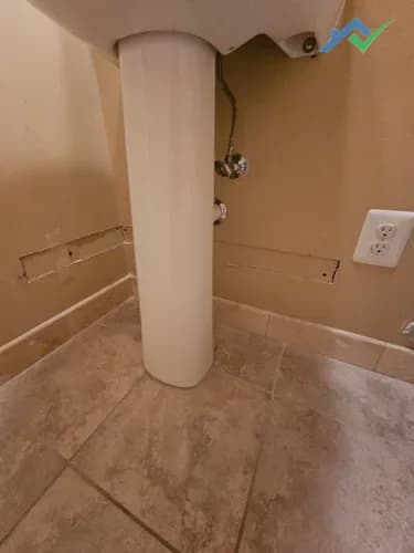 Drywall cutout from electrical work for the new toilet install prior to patching.