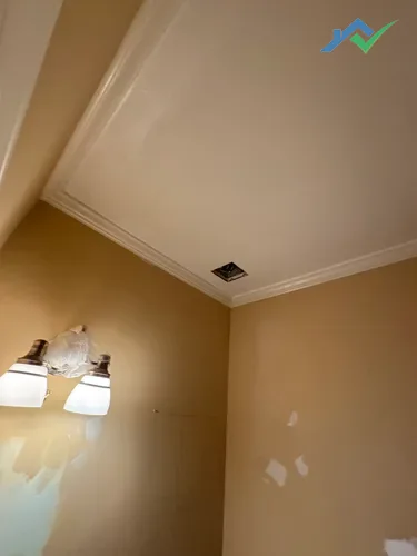 Joint compound being feathered across the guest bathroom wall repair in Purcellville, VA.