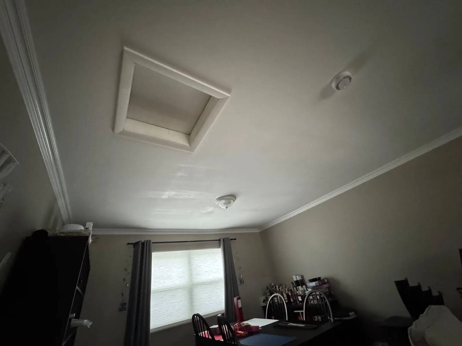 Finished ceiling in Herndon, VA after HouseWorks completed the drywall repair — smooth, freshly painted surface with the attic access hatch (where the insulation crew re-enters), crown molding, and a recessed light all visible.