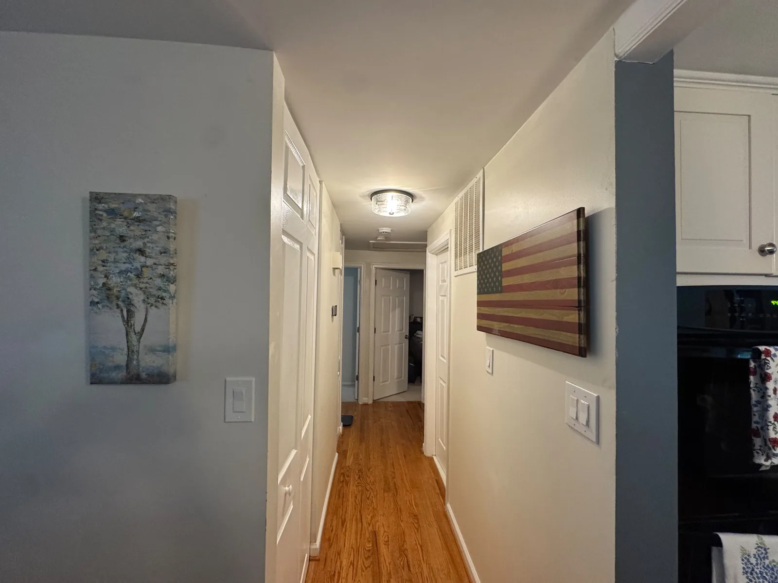 Finished hallway ceiling in this Herndon, VA home after HouseWorks re-secured, patched, primed, and painted the drywall — flush recessed light and clean paint line where the ceiling meets the wall.